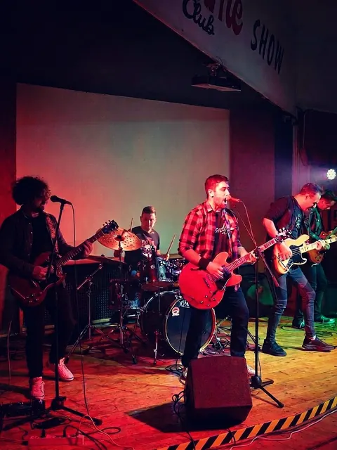La band al completo sul palco, sotto luci rosse